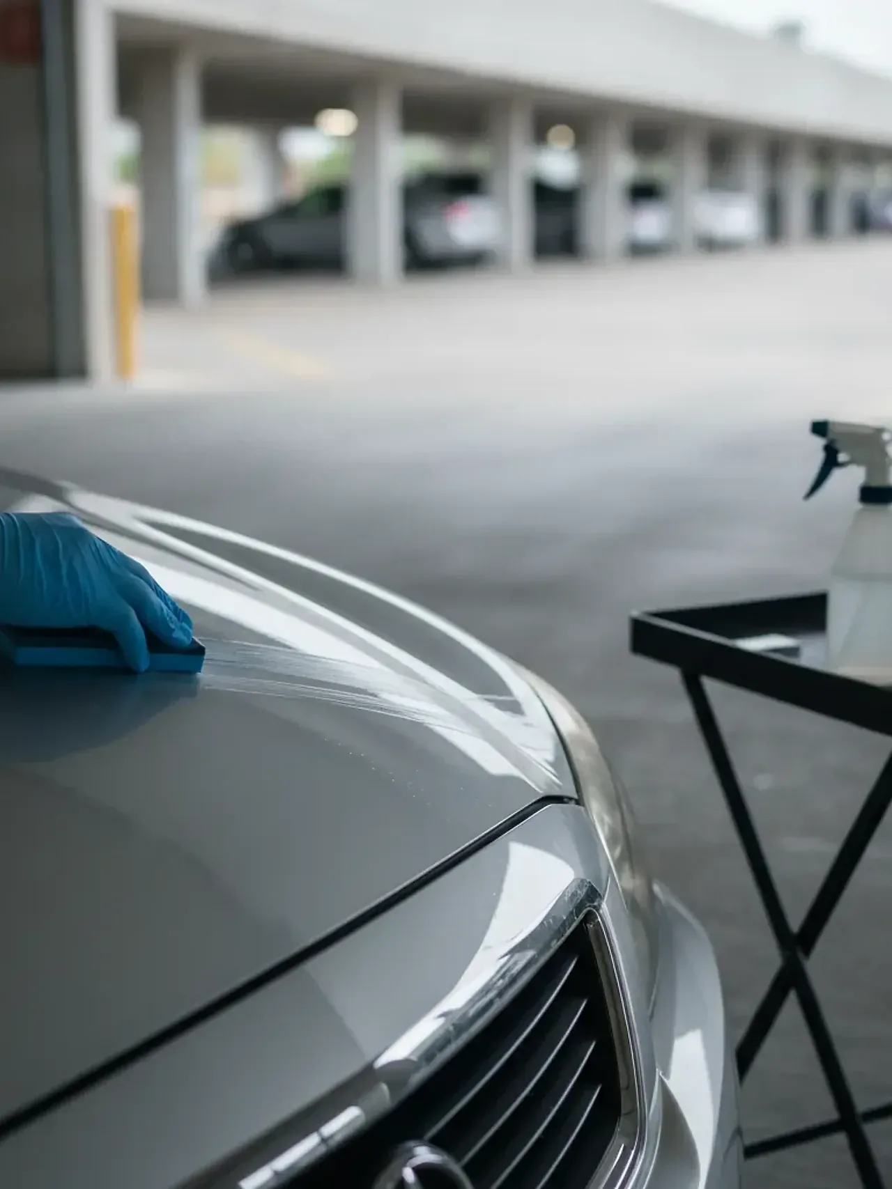 Clay bar treatment being applied to sedan hood in Irving parking garage
