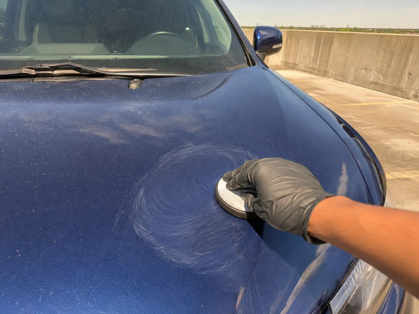 Applying a coat of wax to clean car paint in Irving
