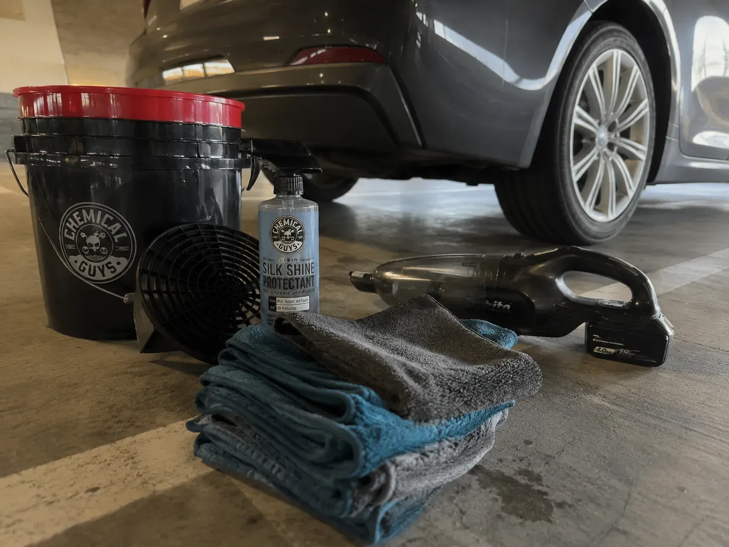 Detailing supplies set out beside a car in an Irving parking garage